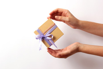 gift in female hands on a light background. Holiday, minimalism, congratulations.