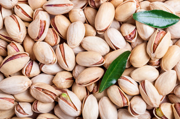 Pistachio background. Pistachio texture with leaves. Nuts. Top view