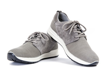 Close-up of elegant gray sport shoes for adult man photographed on white background.