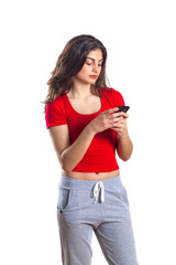 Cheerful attractive young sportswoman using mobile phone over white background