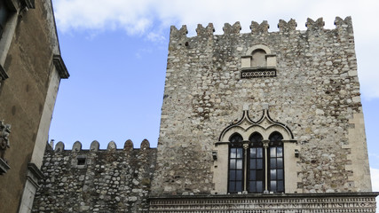 Fototapeta na wymiar View of a ancient tower in the main street of Taormina, Sicily, Italy