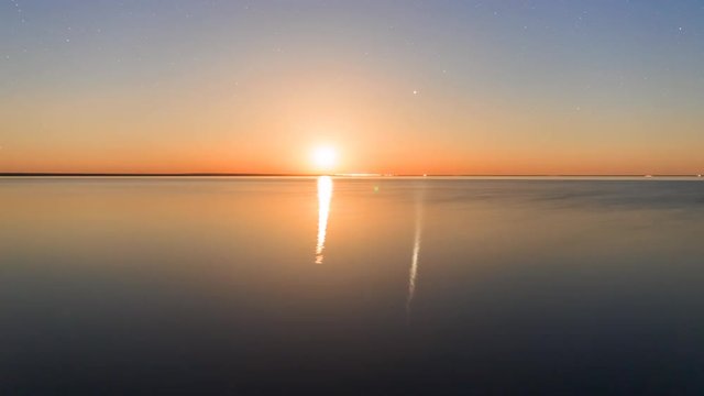 Moonrise over the lake Elton time lapse. Moon and stars above the lake Elton and their reflection on water surface during an entire night.