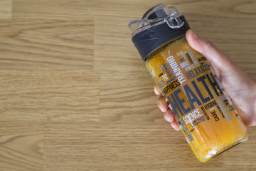 orange juice in the glass bottle on the wooden background for healthy life and sport concept.