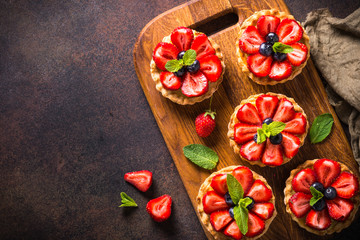 Strawberry tart on dark table.