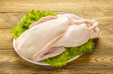 The duck is raw, ready to cook. Gutted carcass of a bird. Wooden table. Recipe preparations. Dietary food. Health food. Farm product.