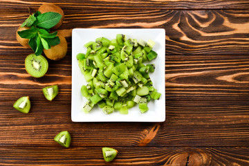 Freshly sliced kiwi fruit with whole kiwis in background.