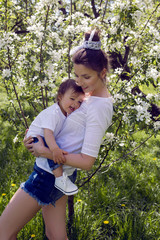 mother and son standing in the trees blooming