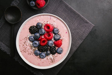 Smoothie bowl on white plate on dark background