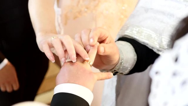 Bride wear ring on groom's finger. marriage hands with rings. birde wears the ring on the finger of the groom