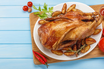 Roast duck on a white platter. Ready to serve poultry. Table setting. Roasted duck on the grill.