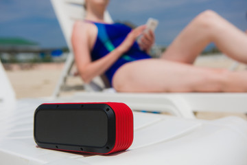 Portable speaker and female with mobile phone
