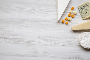 Top view, set of various cheese on a white wooden background. Copy space. Food for wine. Flat lay, from above.