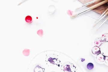 Flat lay brushes, paints, palette of watercolor on a white background