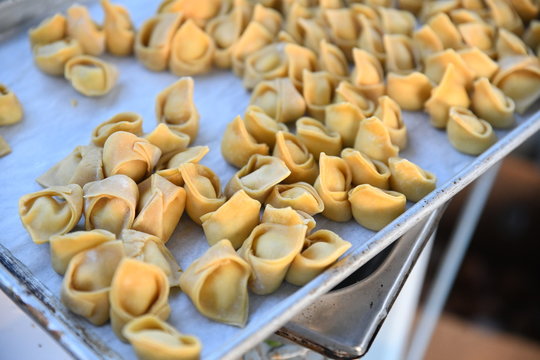 Uncooked tortellini pasta on tray