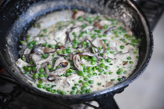 Green peas with mushrooms in saucepan