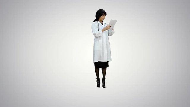 Asian doctor woman look at digital tablet on white background