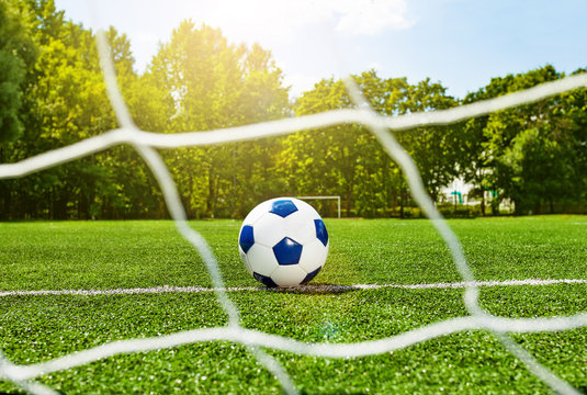 Football Soccer Ball Behind The Gate Net On Field