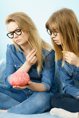 Two serious women friends thinking