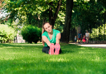 Naklejka na ściany i meble Young woman stretching before a jog