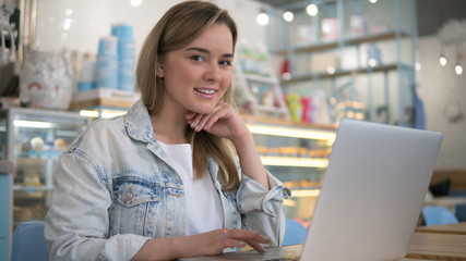 Pretty blonde woman working behind the laptop