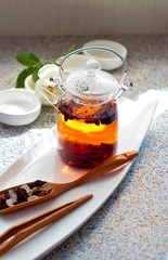 Hot aromatic fruit tea in a glass teapot. Traditional tools for tea drinking and Chinese tea on a light background. The concept of tea drinking. Lifestyle wabi sabi.