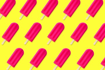 Colorful summer pattern. Bold pink popsicles on a bright yellow background. Top view.
