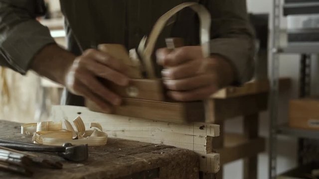 Professional carpenter planing wood with a planer