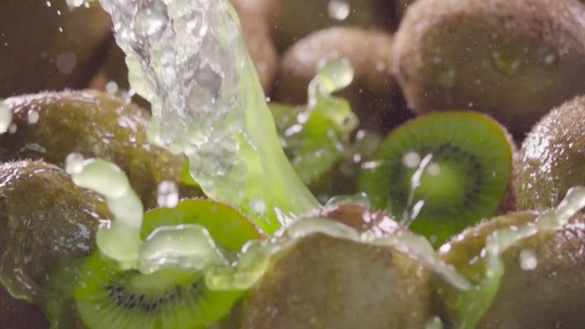 Kiwi falling in juice with splash between kiwis. Slow motion 480 fps. Sony rx10 4 camera