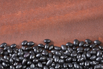 Raw black beans on the wooden background - Phaseolus vulgaris' Black turtle