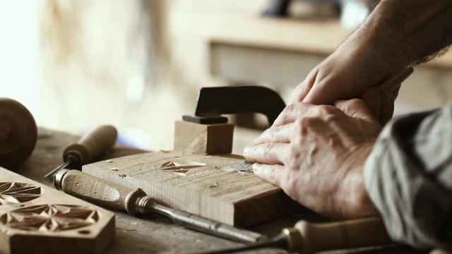 Professional carpenter carving wood using a gouge