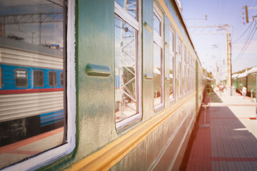 Rail car on the platform. The yellow line on the green. The railway passenger train car is...