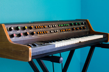 Old synthesizer with colorfull switches on blue background