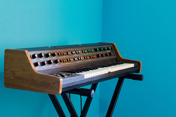 Old synthesizer with colorfull switches on blue background