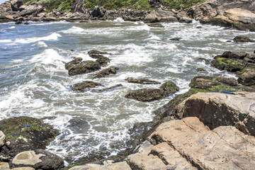 Waves hit the rocks on a beach in Itanhaem
