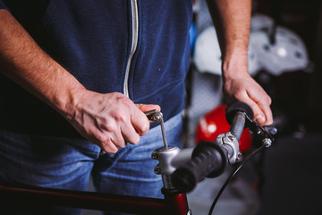 Theme repair bikes. Close-up of a Caucasian man's hand use a hand tool Hex key to install Stems on a bicycle