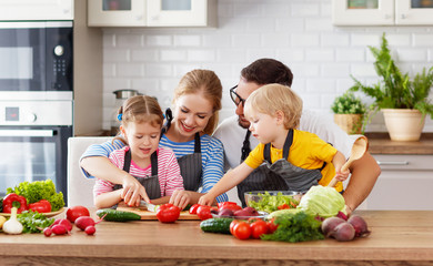 happy family with children preparing vegetable salad .