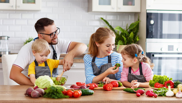 happy family with children preparing vegetable salad .