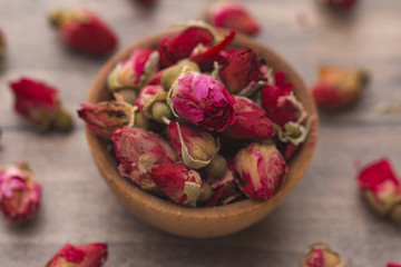 Fototapeta na wymiar Dried Pink Rose Buds in a Brown Bowl