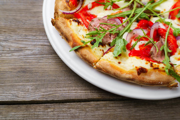 Pizza with veal and arugula, close up, copy space. Delicious italian cuisine, family restaurant, pizzeria, food recipe, pizza delivery concept