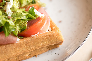 Homemade Belgian Waffle with salad Iceberg, tomatoes and ham
