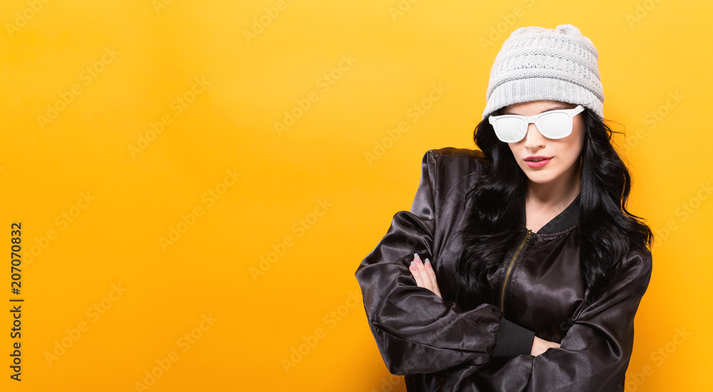 Canvas Prints Fashionable woman with attitude in bomber jacket and sunglasses on a yellow background