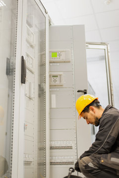 Maintenance engineer testing voltage switchgear and bay control unit