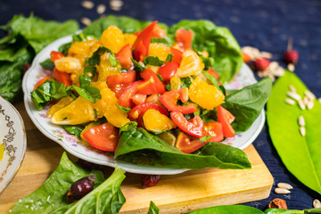 Fresh summer salad with tomatoes, spinach, grapefruit, onion, olive oil, garlic and pink salt. Source of vitamins. Raw vegan vegetarian healthy food.