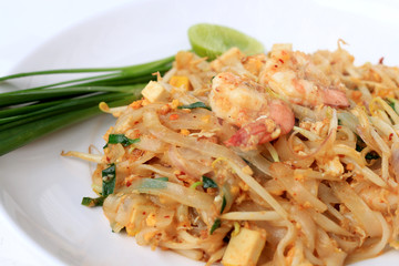 Thai style noodles, Pad Thai, stir-fried rice noodles with shrimp serve with vegetable in white plate on white background. The one of Thailand's national main dish. the popular food in Thailand.
