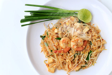 Thai style noodles, Pad Thai, stir-fried rice noodles with shrimp serve with vegetable in white plate on white background. The one of Thailand's national main dish. the popular food in Thailand.