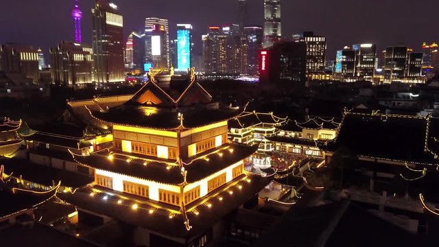 Unique Aerial Around Night illumination Yuyuan Garden Shanghai historical authentic style culture tile roofs Contrast Skyscrapers Pudong Pearl modern colorful glass structure people Travel showplace