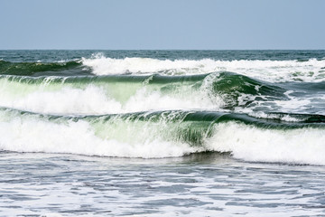 Waves breaking on the Caribbean Sea with blue sky in the background, as a nature background
