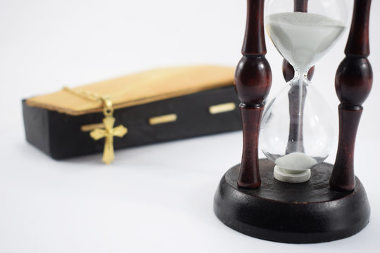 an hourglass and a coffin on a white background, time and death