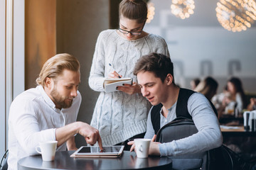 Three Businesspeople Working In cafe