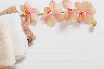 orchid with towels on white wooden background